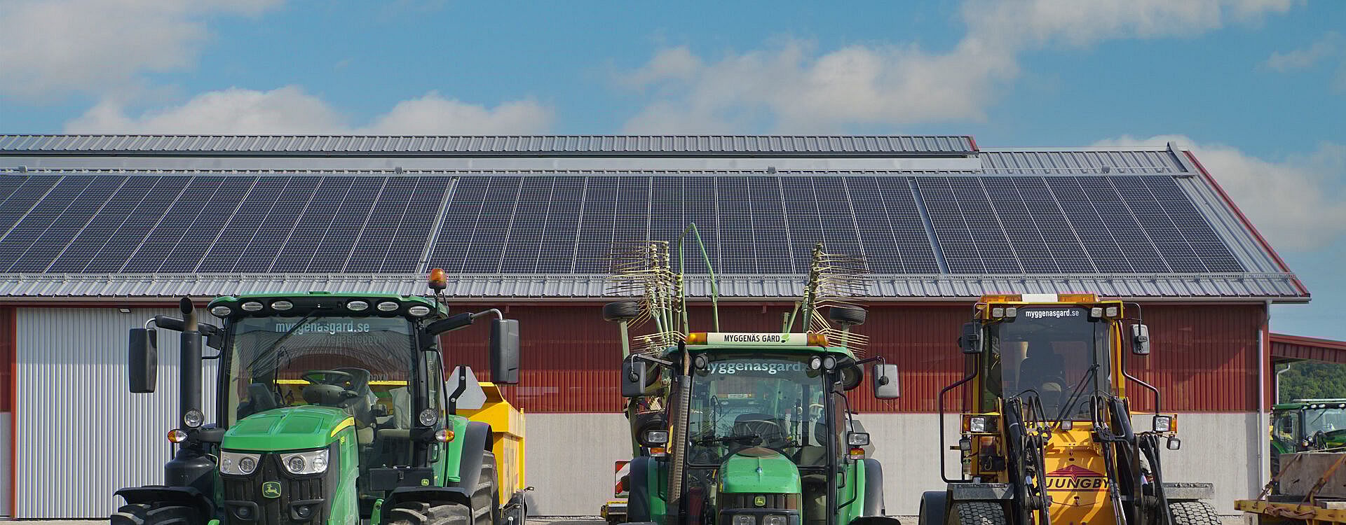 Solceller på lantbrukshall med traktorer i förgrunden