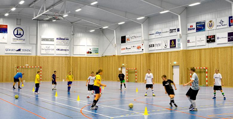Barn spelar fotboll i idrottshall från Borga