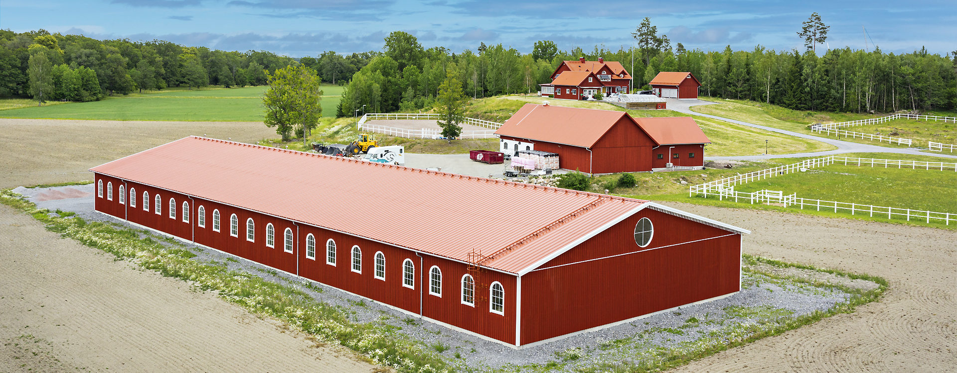 Stor röd lantbrukshall på bondgård