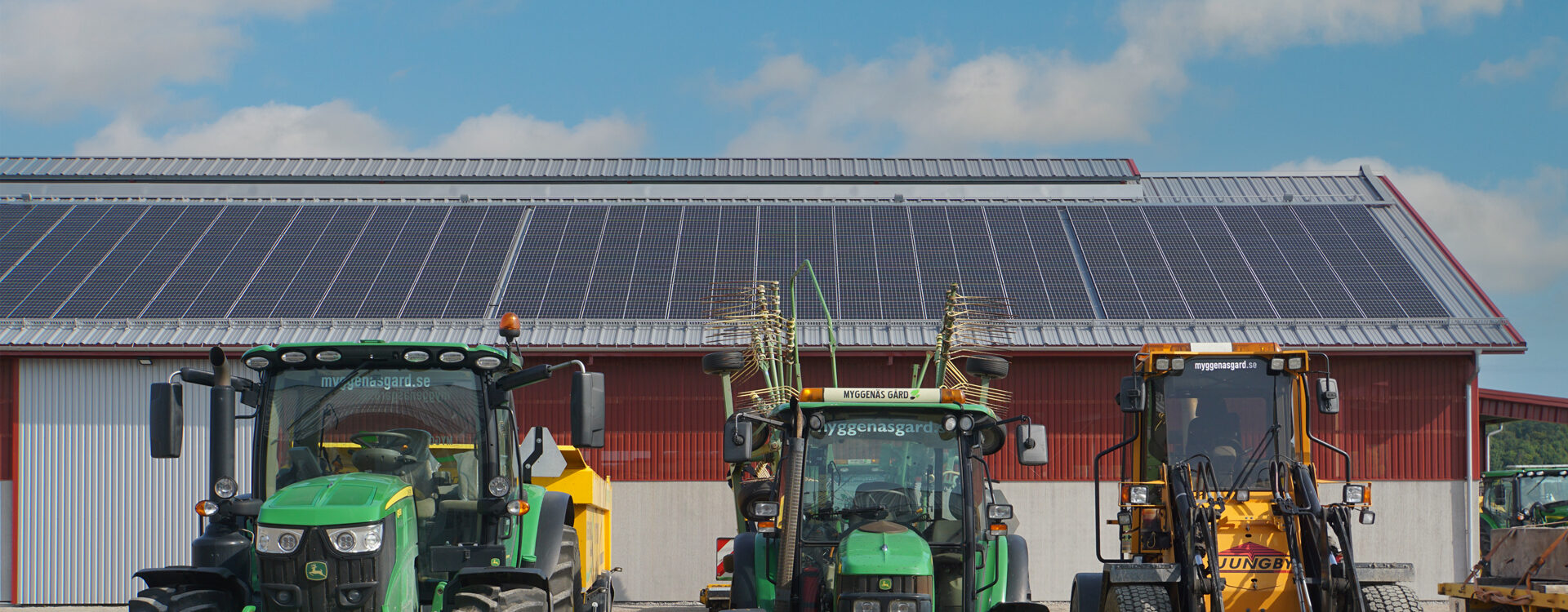 Solceller på lantbrukshall med traktorer i förgrunden